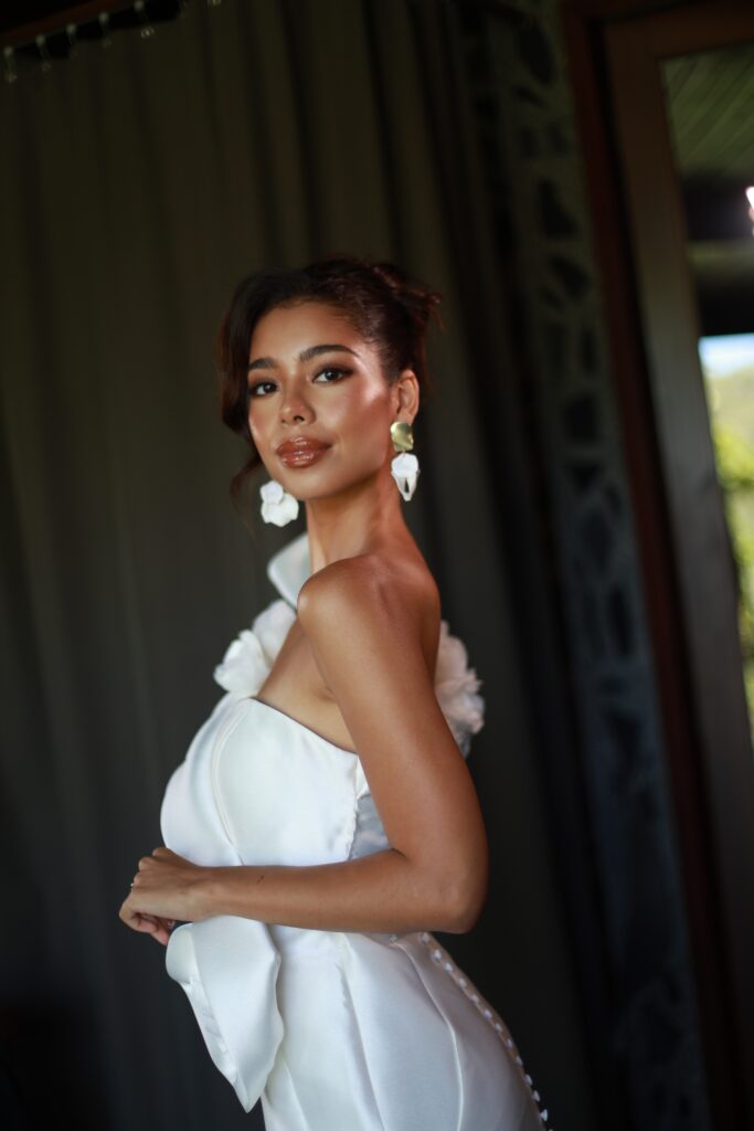 Elegant bridal makeup by a professional makeup artist in Phuket, featuring glowing skin, soft smoky eyes, and natural lip color on a model in a white dress.